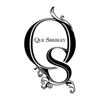 Que Shebley logo